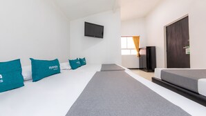 A hotel room with a bed, a TV mounted on the wall, a wardrobe, and a door. - Vittapark (Medellín)