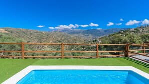 A swimming pool with a wooden fence and a view of mountains. - Cinco Soles Árchez by Ruralidays (Málaga)