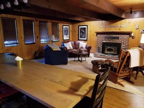 Relax in this inviting living area with a dining table, comfortable sofa, and cozy fireplace.