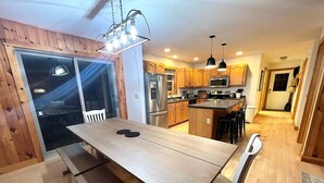 Una cocina moderna con armarios de madera, una isla central y electrodomésticos de acero inoxidable.
