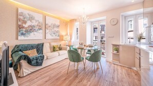 A modern living room with a sofa, a dining table with chairs, and artwork on the walls. - GuestReady - Whole apartment in Lisbon (Lisboa)