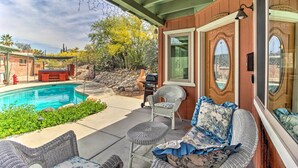 Una veranda coperta con piscina, mobili da esterno e area barbecue.