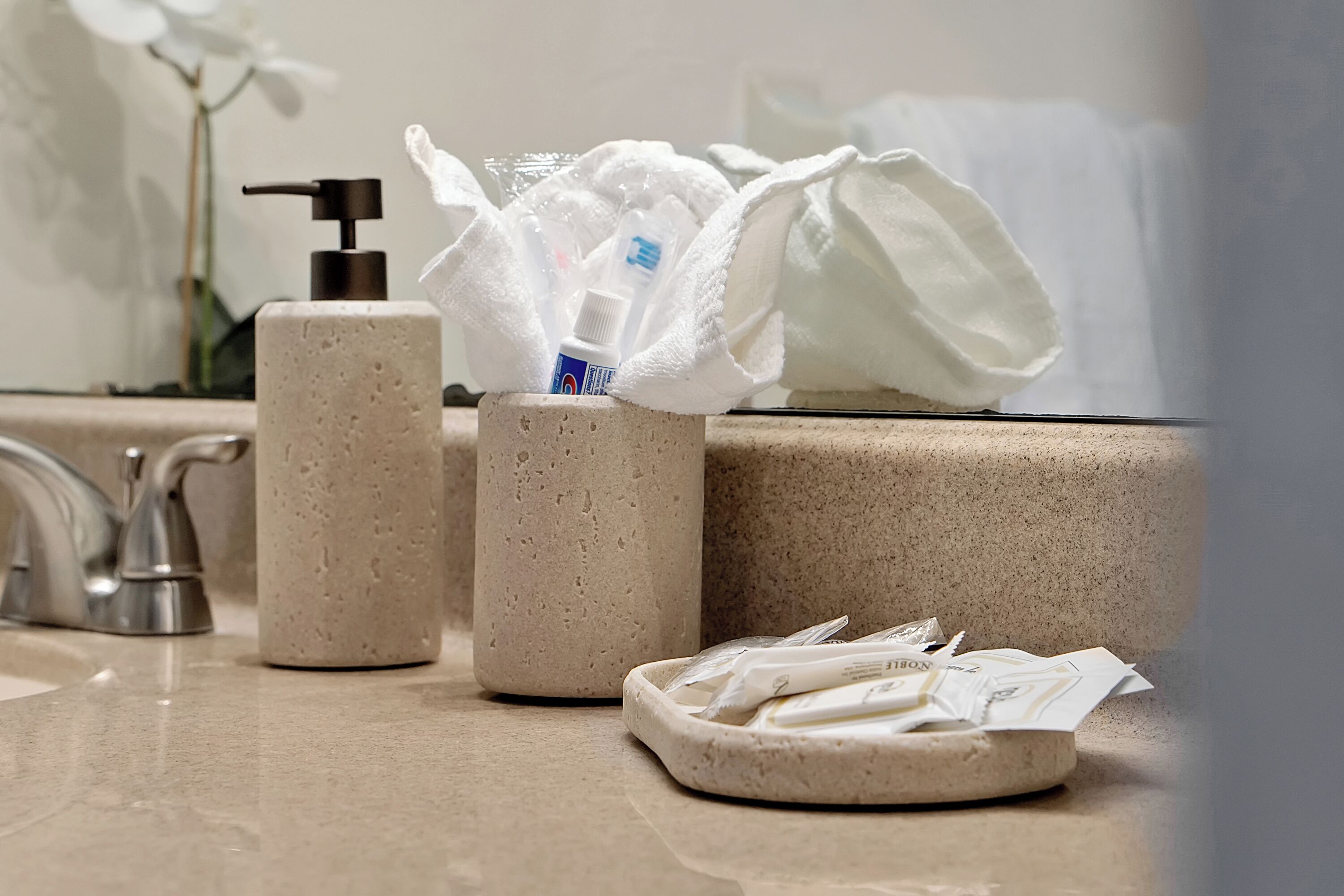 Zona de lavamanos con dispensador de jabón, botella de gel antibacterial y un porta pañuelos con pañuelos.