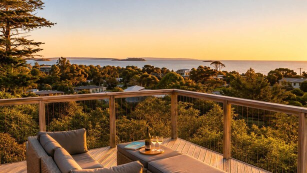 A wooden deck with wicker furniture and a view of the sea. - Hekerua Bay Retreat - Coastal Views (Waiheke Island)