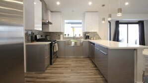 A modern kitchen with stainless steel appliances, a central island, and pendant lighting. - 4 Bedroom Modern Home, Pool+Spa+Guest House! (Palm Springs)