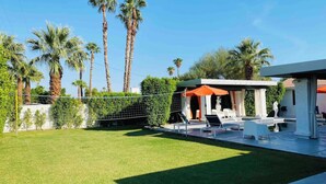 A modern outdoor patio area with a pool, lounge chairs, and a covered seating area. - 4 Bedroom Modern Home, Pool+Spa+Guest House! (Palm Springs)