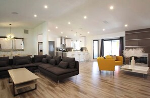 A modern living room with a sectional sofa, a yellow armchair, and a coffee table.