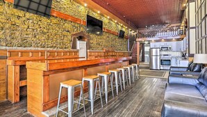 A bar area with stools, a counter, and a stone wall.