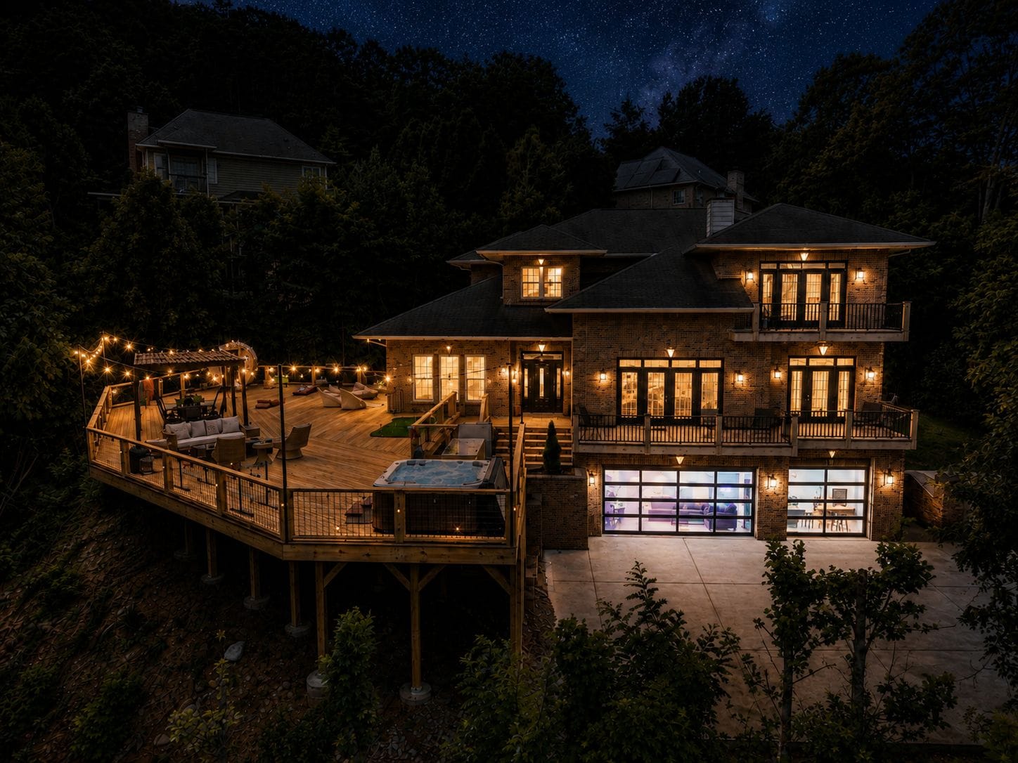 Une maison à deux étages dotée d’une terrasse, d’un espace salon extérieur et d’un jacuzzi.