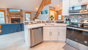 A modern kitchen with a dishwasher, stove, and a large island with a sink. - Hot Tub, Sauna & Game Room, Sleeps 8, Pet OK - Near Camelback (Tannersville)