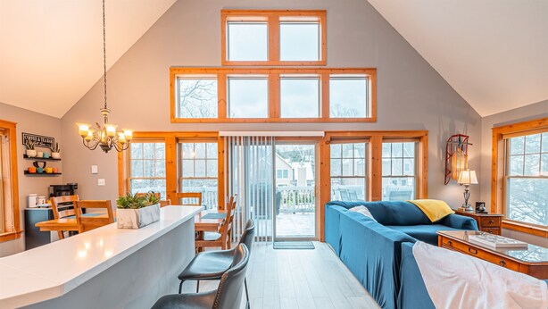 A spacious loft-style room with a high ceiling, a kitchen area, and a seating area with a sofa and chairs. - Hot Tub, Sauna & Game Room, Sleeps 8, Pet OK - Near Camelback (Tannersville)