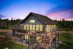 Una casa de dos pisos con terraza, garaje y un patio.
