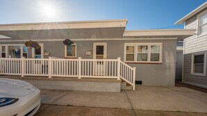 A single-story house with a white picket fence, a front porch, and a car parked in the driveway. - Sweet and Spacious Stay Two Blocks from Wildwood's Best Beaches (Wildwood)