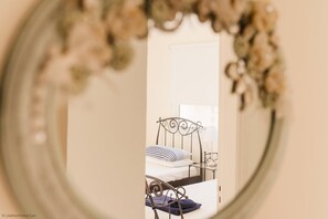 Un dormitorio con estructura de cama de metal, una mesita de noche y una lámpara.