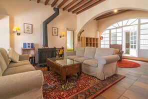 A cozy living room with a fireplace, comfortable seating, and a large window.