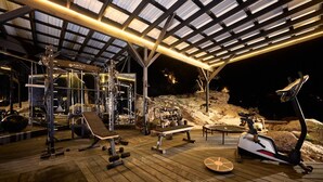A gym with various exercise equipment, a bench, and a rowing machine. - Paradise Ranch Inn- Limitless House Hot Tub,Sauna. (Three Rivers)
