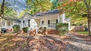 A single-story house with a front porch, a brick foundation, and a driveway. - Cozy Renovated Home 1 mile to DT w/ Fenced in Yard (Raleigh)