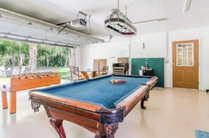 Enjoy a game of pool or foosball in this well-lit recreational area with a pool table and foosball table.