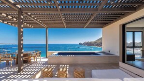 Eine Dachterrasse mit Pool, Sitzgelegenheiten im Freien und Blick aufs Meer.