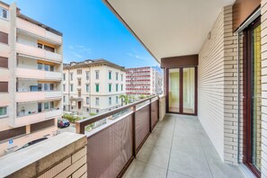A balcony with a view of neighboring buildings, a tiled floor, and a glass door. - Locarno best place, Locarno, Switzerland (Locarno)