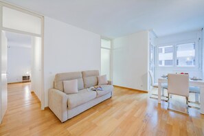 Ein modernes Wohnzimmer mit einer Couch, einem Esstisch und einem Sessel.