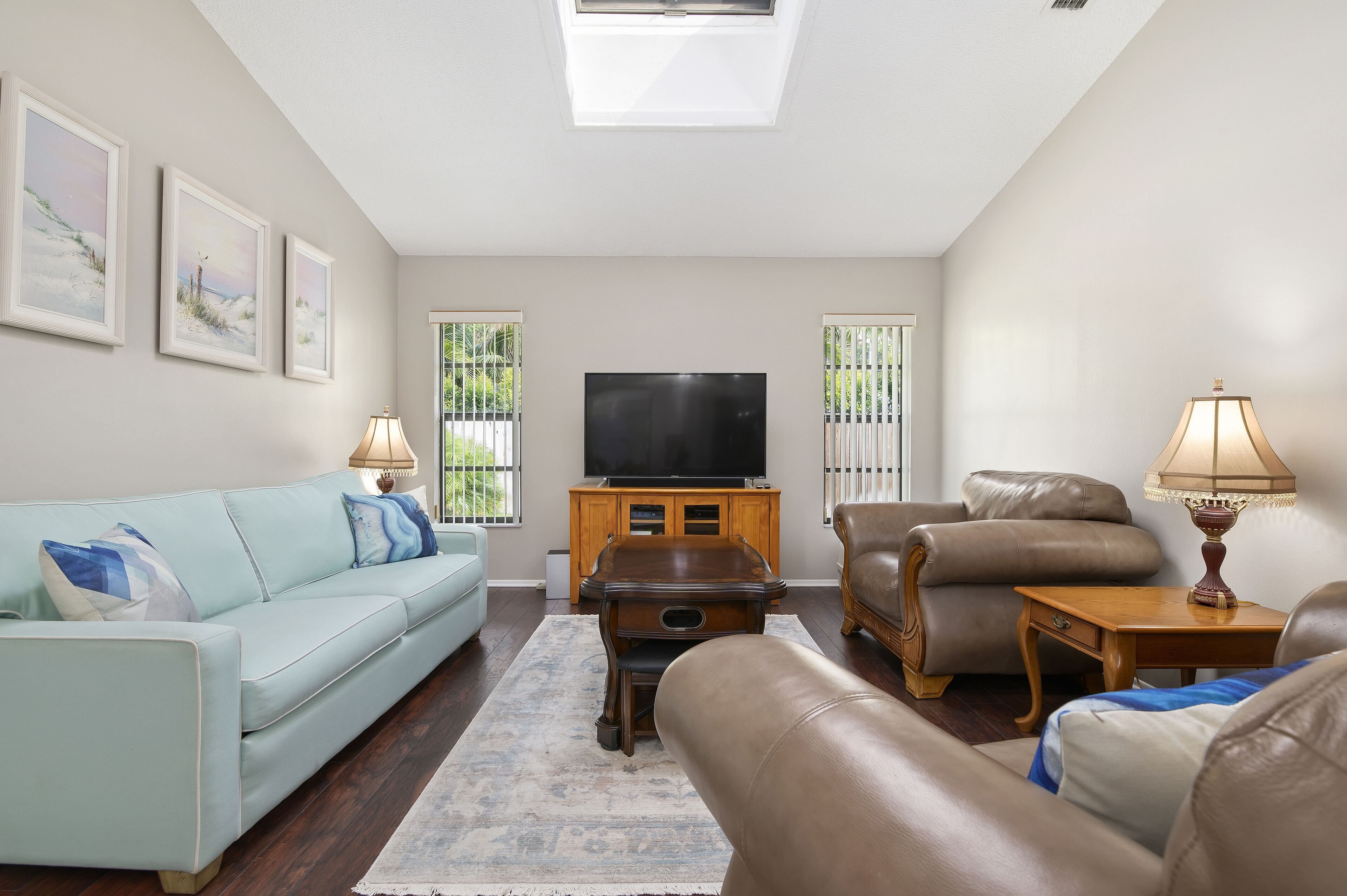 A living room with a sofa, a coffee table, a TV, and a lamp.