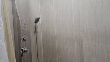 A modern shower with a curved design, a handheld showerhead, and a rain shower head.