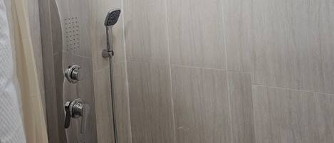 A modern shower with a curved design, a handheld showerhead, and a rain shower head.