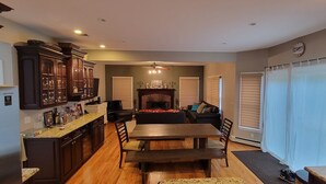A modern kitchen with dark wood cabinets, a granite countertop, and a built-in dishwasher. - Spacious home near Aquarium & heart of wine country Shopping & close to Hamptons (Riverhead)