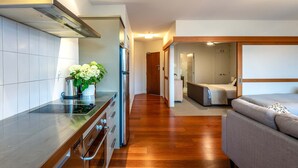 A modern kitchen with a built-in oven, a stainless steel range hood, and a wooden countertop.