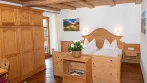 A wooden bedroom with a bed, bedside tables, and a wardrobe. - 1 Appartement , Balkon, Kochnische, 1 Wohn-/schlafzimmer, max 2 Pers, Wlan (Ruhpolding)