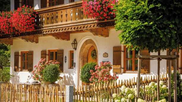 A traditional chalet with wooden balconies, a stone archway, and a wooden fence. - 4 Fewo , Balkon, Kochnische, 1 Schlaf- und 1 Wohn-/schlafz. max 4 Pers, Wlan (Ruhpolding)