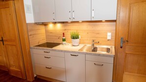 A kitchen with wooden cabinets, a sink, and a countertop. - 4 Fewo , Balkon, Kochnische, 1 Schlaf- und 1 Wohn-/schlafz. max 4 Pers, Wlan (Ruhpolding)