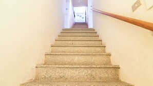 Eine Treppe mit Geländer, die zu einer Zwischenebene führt.