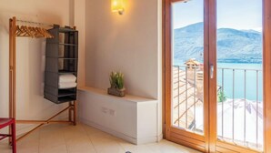 A room with a large sliding glass door leading to a balcony with a mountain view.