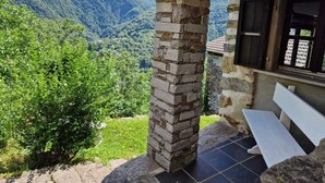 A stone pillar, a bench, and a view of a mountainous landscape. - Mountain worlds behind Lake Maggiore (Falmenta)