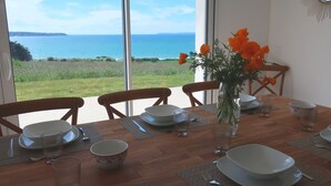 A dining table set for four with a view of the ocean.