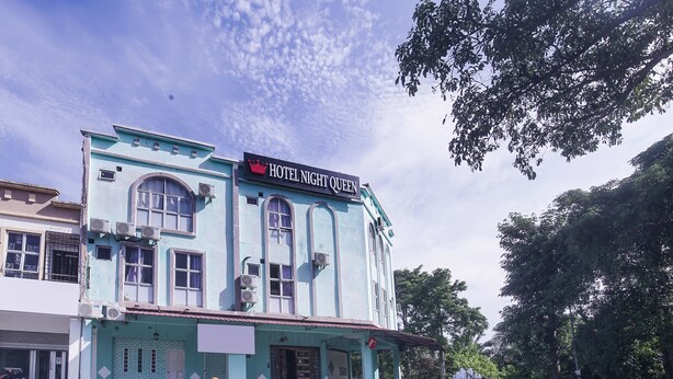 A hotel named "Hotel Night Queen" with a classic architectural style, featuring arched windows and a prominent sign.