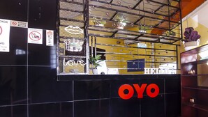 A reception area with a black counter, a 'NO SMOKING' sign, and a 'WELCOME' sign.