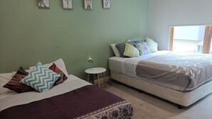 Ein Schlafzimmer mit zwei Betten, einem kleinen runden Tisch und einer Wand mit gerahmten Bildern.