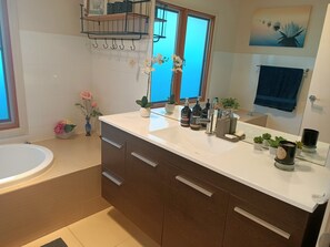 Tina con regadera, toallas, jabón, papel de baño 
