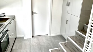 Een moderne keuken met een ingebouwde oven en een witte deur.