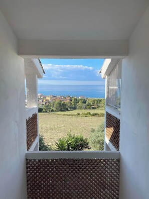 A balcony with a view of a coastal town and a clear sky.