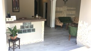 A spacious living area with a bar counter, seating, and a decorative wall. - Merve Apart Otel (Alanya)