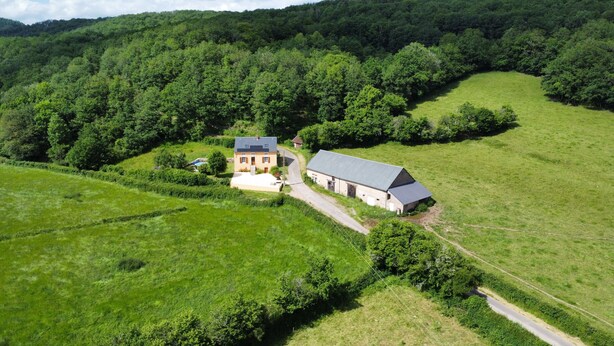 An aerial view of a rural property with a large barn, a smaller house, and surrounding green fields. - Gîte les Meulots, isolated in the Morvan nature park (Blanot)