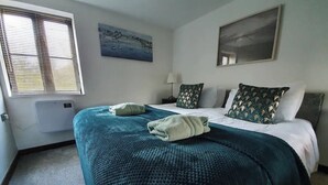 A hotel room with a bed, a window with blinds, a painting on the wall, and a bedside table with a lamp. - Bonneys Barn Retreat - Luxury homely getaway (000)
