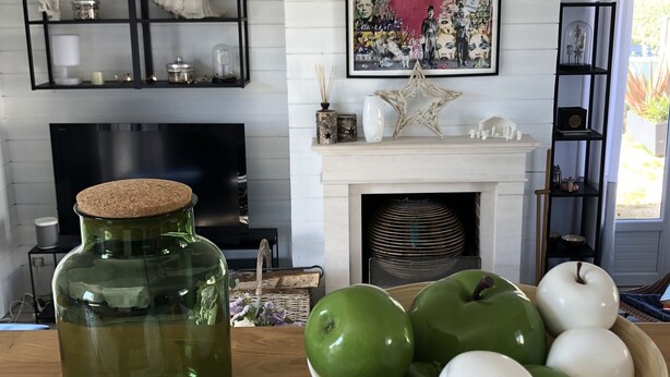 A living room with a fireplace, a television, and a decorative painting.