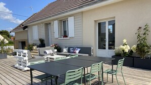 A deck with a table and chairs, a sofa, and a potted plant.