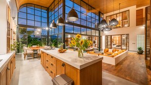 Una cocina amplia con una isla grande, armarios de madera e iluminación colgante.