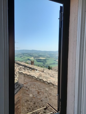 A view from a window overlooking a rural landscape with rolling hills and a clear sky. - Immaculate 2-rooms Apartment in Todi , Umbria (Todi)